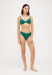 Turkise bikini med lett polstret underwire topp med justerbare stropper og matchende høyt midje briefs. Glatt, elastisk stoff.