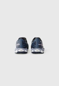 Baskets de course bleu marine avec une tige en maille respirante, semelle blanche et accents texturés. Comprend un logo sur le talon.