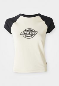 Cremfarbene T-Shirt mit schwarzen Raglanärmeln, das ein kreisförmiges Logo mit dem Text "Dickies" in der Mitte auf weißem Hintergrund zeigt.