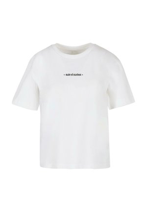 Vit bomull t-shirt med korta ärmar, rund hals och en svart text som lyder "gjord av stjärnstoft" över bröstet. Enkel design.