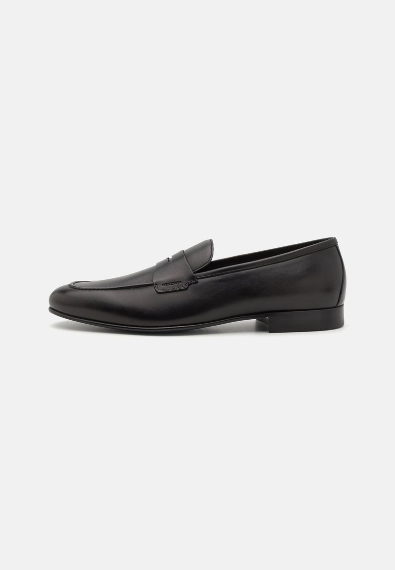 Mocassins en cuir noir au design épuré, à bout arrondi et talon bas empilé. Présentent un détail décoratif en couture sur le dessus.