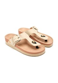 Sandalias beige con separador en los dedos, hebilla ajustable y detalles en dorado. Plantilla suave con una suela texturizada de color marrón claro y detalles en negro.