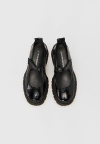 Μαύρα παπούτσια από πατент δέρμα με στρογγυλή μύτη, ρυθμιζόμενη θηλιά και παχύ, υφασμένο καουτσούκ σόλα. Το μέγεθος 37 αναγράφεται στο εσωτερικό.