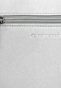 Sidabro tekstūruotas dirbtinės odos maišelis su užtrauktuku, turintis įspaustą "TOM TAILOR" ženklą.