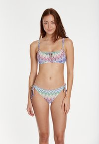 Dvodijelni bikini s višeplavim uzorkom u obliku cik-caka. Gornji dio ima četvrtasti izrez i prednji vez, dok donji dio ima bočne vezice.