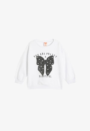Sweatshirt blanc avec un col rond et des manches longues. Présente un graphique de papillon noir avec une surface texturée et scintillante, ainsi que du texte imprimé.