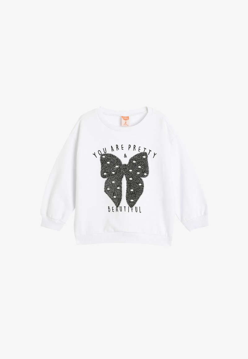 Biała bluza z okrągłym dekoltem i długimi rękawami. Posiada czarny graficzny motyw motyla o teksturowanej, błyszczącej powierzchni oraz nadrukowany tekst.