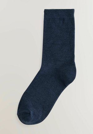 Laivastonsiniset sukat, jotka on valmistettu pehmeästä kankaasta, jossa on sileä pinta, normaali nilkkapituus ja pyöristetty varvastyyny ilman kuvioita.