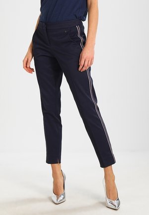 Pantalons navy à coupe slim, avec une bande latérale contrastante et de petites fentes au niveau de l'ourlet. Fabriqués dans un tissu lisse et durable.