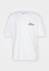 Witte katoen T-shirt met korte mouwen en een ronde halslijn. Heeft zwarte cursieve tekst "Inferno" op de linkerborst. Soepele textuur.