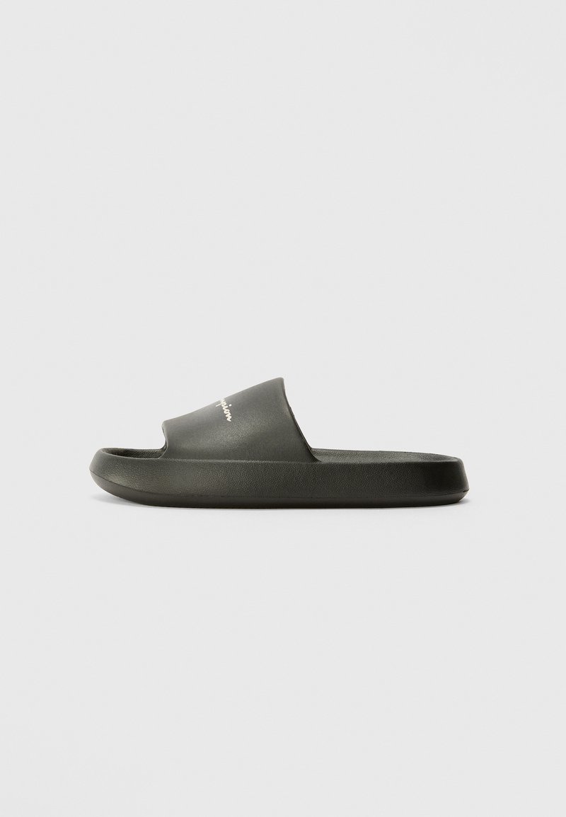 Sorte sandaler laget av glatt gummi med en bred horisontal stropp og en teksturert såle. Har subtil logo-detaljering på stroppen.