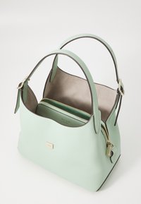 Mint green leather handbag with a structured shape, dual top handles, and a gold zipper accent. Interior features a zippered pouch.