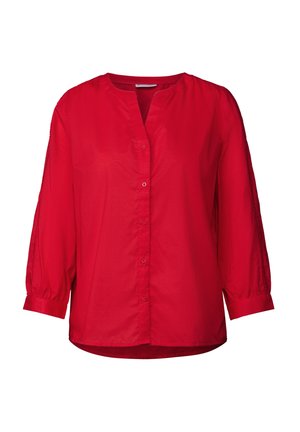 Rød bluse med lange ærmer, V-udskæring og knaplukning foran. Har let puffede ærmer og teksturerede detaljer langs sømmene.