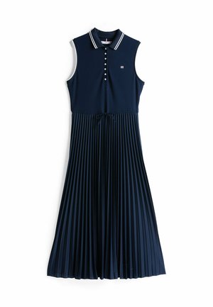 Navy blå polo kjole med krave, knaplukning og en plisseret nederdel. Har hvid kant og snoretræk i taljen.