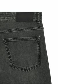 Jeans in denim grigio scuro presentano una tasca posteriore con un logo discreto, cuciture a contrasto e un'etichetta in pelle con il nome del marchio in vita.