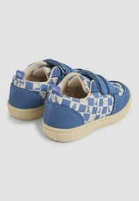 Scarpe blu per bambini con strappi in velcro, caratterizzate da un motivo a scacchi e disegni giocosi in bianco. Tessuto testurizzato e suole in gomma.