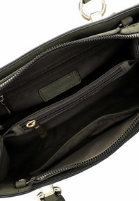 Black handbag with gold hardware, featuring an interior zippered pocket and two open compartments, lined in olive green fabric.