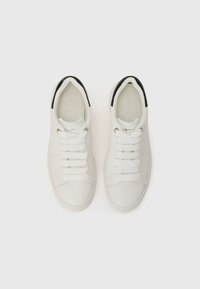 Vita lädersneakers med svarta accenter, platta snörning och perforerade detaljer på sidorna. Rund tå och platt gummisula.