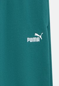 Φόρμες Puma σε τυρκουάζ με υφή υφάσματος. Διαθέτουν λευκό κεντημένο λογότυπο στο αριστερό μηρό. Απλός σχεδιασμός με άνετη εφαρμογή.