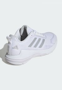 White athletic shoe with a textured mesh upper, silver three-stripe design, padded collar, and a rubber sole with grip pattern.