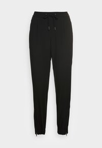 Pantalones de chándal negros con cintura elástica y cordón. Cuenta con dos bolsillos frontales y puños con cremallera. Textura de tela suave.