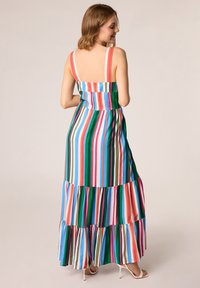 Sukienka maxi z pionowymi paskami w kolorach zielonym, niebieskim, różowym i pomarańczowym. Materiał: lekka tkanina. Projekt zawiera regulowane ramiączka oraz warstwowy dół.