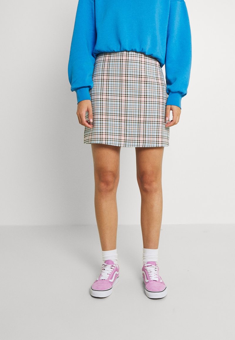 Checkered mini skirt with blue, pink, and cream patterns, paired with a light blue sweater and pink sneakers with white accents.