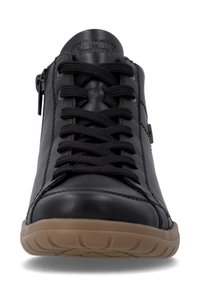 Chaussure décontractée en cuir noir avec lacets noirs et semelle en caoutchouc marron, vue de face montrant les coutures détaillées et la fermeture éclair latérale.