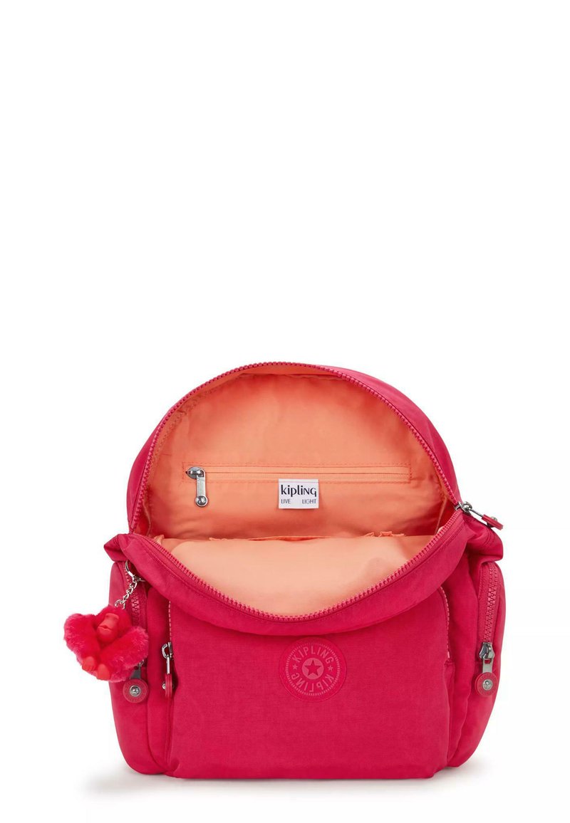 Sac en tissu rose Kipling avec une fermeture éclair en haut ; dispose d'une doublure orange, d'une poche intérieure et d'un porte-clés charm. Logo rond à l'avant.