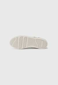 Sole di sneaker bianca in gomma testurizzata, con scanalature definite per una buona presa e un leggero arco. Dimensione 37 stampata sul lato.