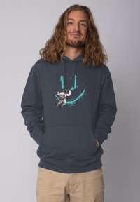 Marinefarbener Hoodie mit einer Fronttasche, der ein Astronautenmotiv und türkisfarbene Spritzer zeigt. Weicher Stoff mit langen Ärmeln und verstellbarem Kordelzug an der Kapuze.