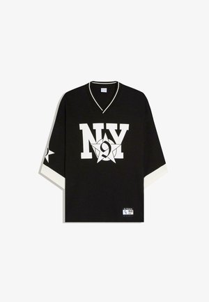 Črna športna majica z V-izrezom, na sprednji strani bel napis "NY" in številka 9 znotraj zvezde, beli robovi na rokavih ter majhna etiketa na spodnjem robu.