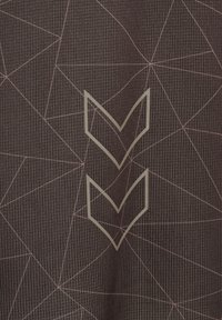 Brunt teksturert stoff med tynne geometriske linjemønstre og to reflekterende doble chevron-symboler stablet vertikalt i midten.