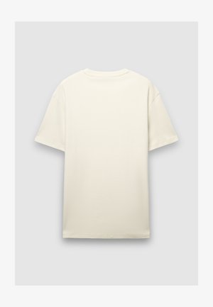 T-shirt a maniche corte, dalla vestibilità ampia, di colore crema, caratterizzata da un collo tondo e da un tessuto di cotone liscio e leggermente strutturato. Senza grafiche o design.
