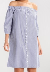 Blå och vit randig klänning med off-shoulder-design, trekvartslånga ärmar, knappframsidan och lätt material, med en avslappnad passform.