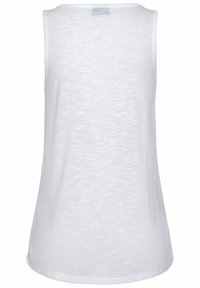 Bílé tílko bez rukávů z lehké, měkké látky s jemnou strukturou. Má kulatý výstřih a zaoblený lem.