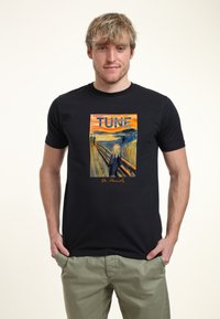 Camiseta de algodón negra con una gráfica de "El Grito" de Edvard Munch, con la palabra "TUNE" encima de la obra en letras grandes.