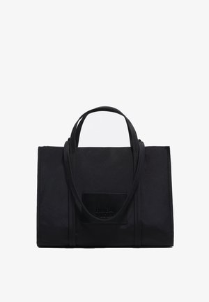 Bolso tote negro de material texturizado, con dos asas superiores, frente liso y parche con marca en la parte inferior.