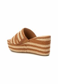 Infradito a zeppa marroni e beige con texture intrecciata, punta aperta e una piattaforma di 3 pollici. Presenta un design superiore arcuato e intrecciato.