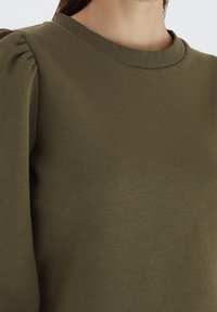 Dunkelgrüner Sweatshirt mit Rundhalsausschnitt und gerafften Ärmeln. Glatte Oberfläche, aus leichtem Material gefertigt, geeignet für legere Anlässe.