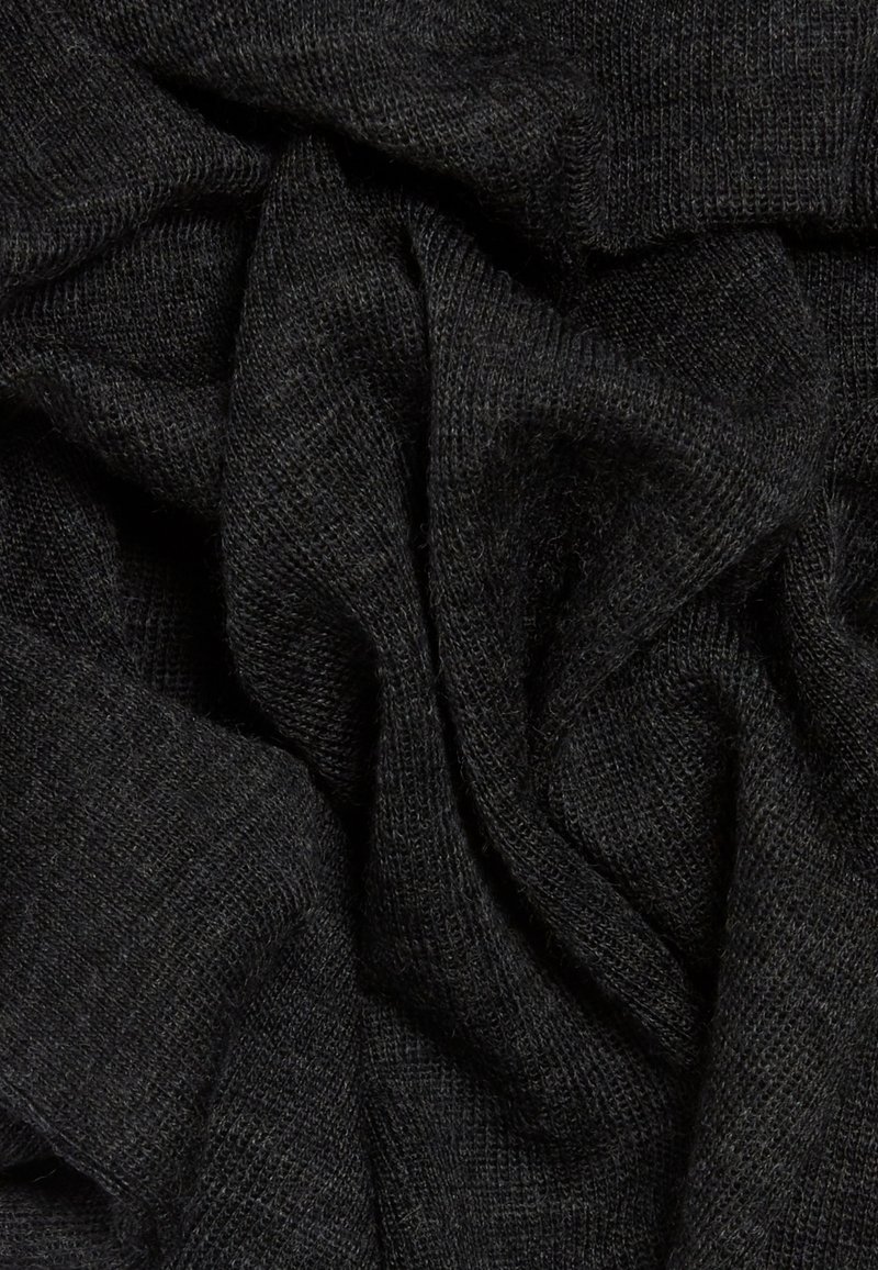 Zwart gebreide stof met een zachte, gestructureerde oppervlakte, met onregelmatige plooien en kreuken die de elasticiteit en val benadrukken.