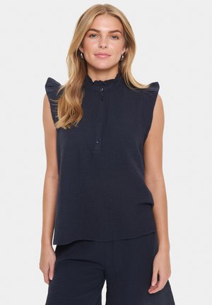 Top sans manches bleu marine avec une finition texturée, détails de manches froncées, patte de boutonnage sur le devant et coupe décontractée.