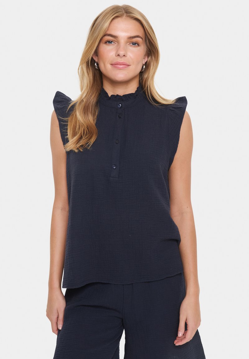 Kara jūras zila bez piedurknēm augšdaļa ar teksturētu apdari, ar volānu plecu detaļām, pogām priekšā un brīvu piegriezumu.