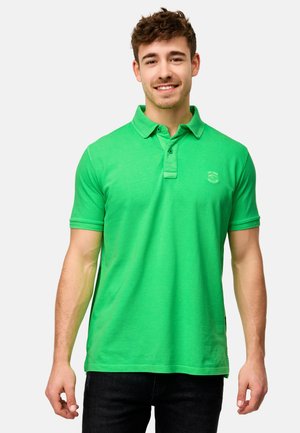 Grøn polo-shirt lavet af blødt bomuld, med klassisk krave, to-knap lukning, korte ærmer og et lille logo på brystet.