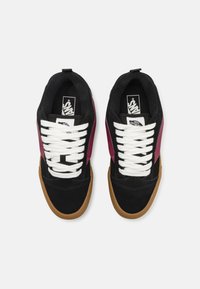 Baskets en daim noir et bordeaux avec des lacets blancs, une semelle en caoutchouc beige et un logo Vans sur la languette pour un branding distinctif.