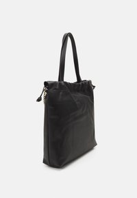Sort tote bag med en blød, glat tekstur. Den har en snørelukning, stilfulde håndtag og et guldfarvet hardware-detalje på siden.