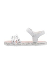 Sandalia blanca con múltiples correas trenzadas y una correa de velcro en el tobillo. Presenta una plantilla rosa y una suela texturizada y con patrón.