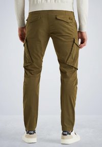 Pantalons cargo en vert olive, fabriqués en tissu résistant, avec des poches zippées, une coupe slim et des jambes fuselées, associés à des baskets blanches.