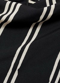 Tissu noir avec des rayures blanches verticales. La texture semble lisse avec un léger brillant. Les rayures varient en largeur et en espacement.