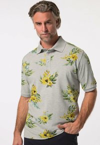 Grå pikétröja med gula blommönster och gröna blad, tillverkad av mjukt tyg med krage och treknappsstängning.